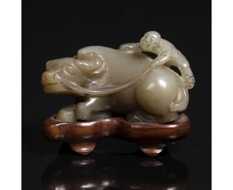 A Chinese jade carving of a reclining buffalo 19th Century with a youth upon its back, with fitted stand, 2.5cm x 4.5cm From 