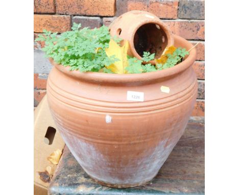 A terracotta garden planter and a smaller planter with pierced hole design