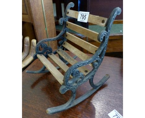Miniature rocking chair in style of a bench with wrought iron bench ends. H: 22 cm