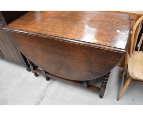 An early 20th Century oak twist gateleg dining table, width approx. 106cm