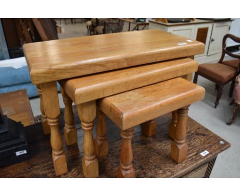 A nest of three modern light oak tables, of traditional design