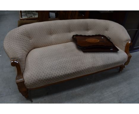 An Edwardian light mahogany framed salon style settee or couch with carved arm detailing