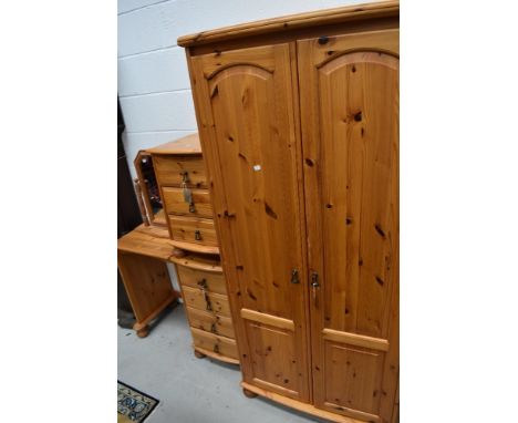 A modern pine bedroom suite comprising wardrobe, bedside chest, dressing table and mirror