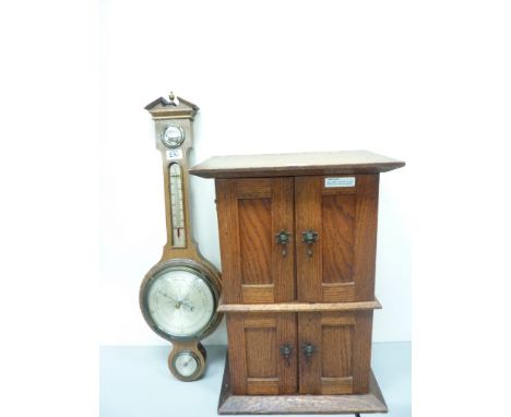 Early 20th century oak cabinet enclosed by four panelled doors H56cm and an oak barometer