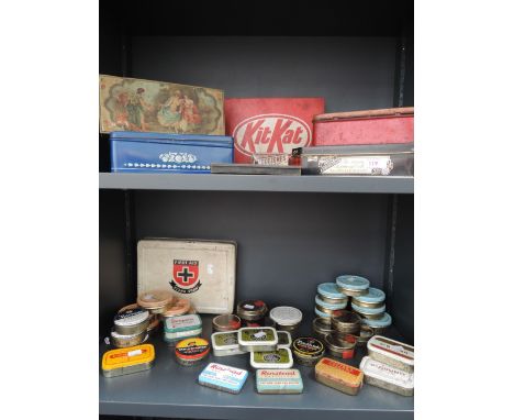 Two shelves of vintage tins
