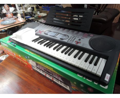 A Casio lk35 key lighting keyboard in box and another similar unboxed