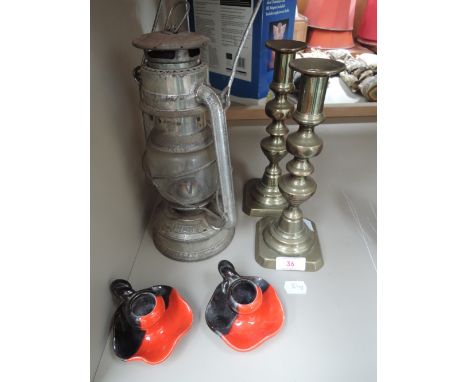A vintage oil lamp and pair of brass candlesticks and ceramic candlesticks