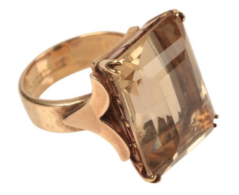 A VINTAGE 9CT GOLD SMOKEY QUARTZ RINGthe step cut smoky quartz claw set to stylised shoulders on a hammered shank, hallmarked