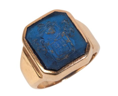 A CARVED SPINEL SIGNET RINGset in yellow gold, the blue spinel measuring approx. 13.67mm x 11.64mm x 4.45mm, featuring a coat