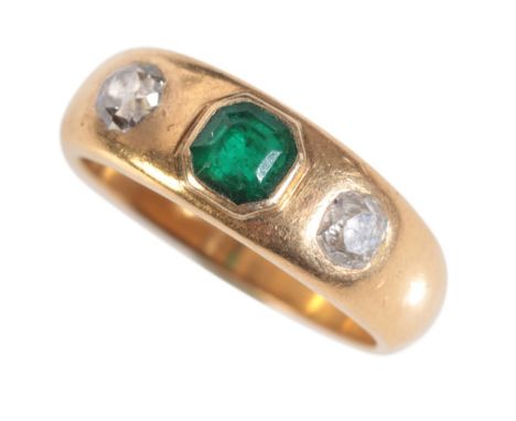 A GOLD EMERALD AND DIAMOND GYPSY RINGset with a central step cut emerald flanked by old mine cut diamonds, on a yellow gold s