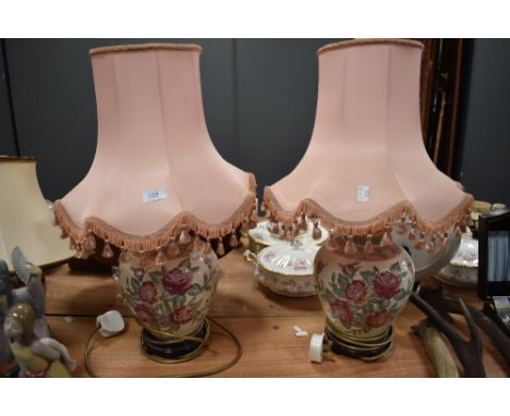 Two large ceramic table lamps with pink shades having pink rose design.