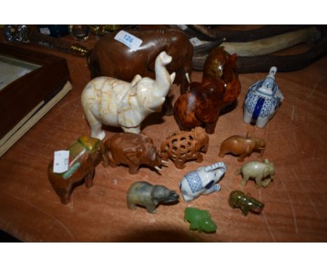 A collection of elephant ornaments, different styles and sizes including wood and ceramic examples.
