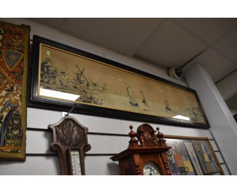A large framed seascape and windmill embroidery.