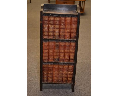 18 part leather bound volumes of the Charles Dickens, Published by The Educational Book Company. Library on a small bookshelf