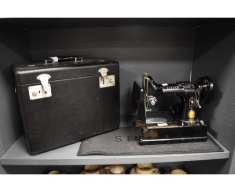 A 1950s Singer sewing machine, model 222K, serial number EK326470, with original case and manual etc