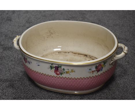 A late 19th or early 20th Century Minton's footbath of two handled oval form with floral transfer print over pink textured pa