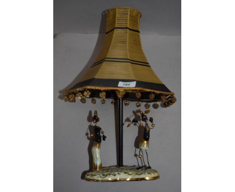 A mid century table lamp,having ceramic base with two ethnic figures.