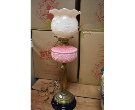An impressive antique oil lamp, converted to electric with opaque shade and pink vaseline glass reservoir on brass Corinthian
