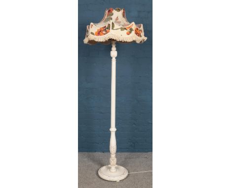 A white painted standard lamp with floral shade.  