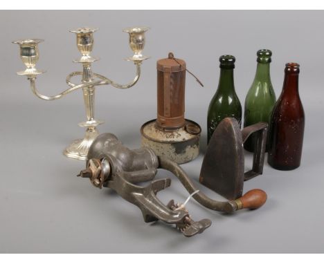 A quantity of collectables. Includes vintage paraffin lamp, glass brewery bottles, mincer, candelabra and an iron.  