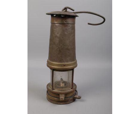 A vintage miners lamp. Stamped 1090 on the front. H: 26cm.  Some dents to the top.