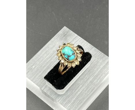 A Middle Eastern gold ring with central turquoise stone (Approximate size K)