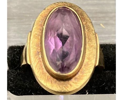 A gold ring, marked 585 total approximate weight 4.3g with central purple stone. Size L