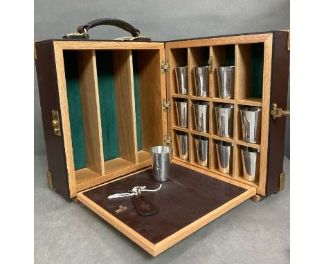 Leather and brass banded drinks companion/field bar, opening to shot cups and four bottle holders 