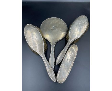 Hallmarked silver backed mirror, and three brushes