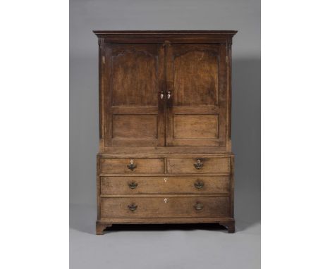 A GEORGIAN OAK CUPBOARD ON CHEST, c.1800, the moulded and parquetry banded cornice over two ogee twin panel doors enclosing a