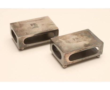 A PAIR OF SILVER MATCHBOX HOLDERS, maker Hutton & Sons Ltd., Birmingham 1928, of plain oblong form raised upon four ball feet