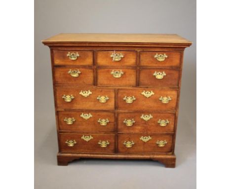 AN OAK CHEST, part 18th century, the moulded cornice over six small drawers, six larger drawers below, brass drop handles, mo