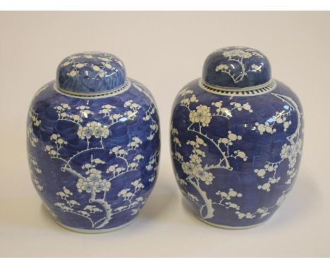 A PAIR OF CHINESE PORCELAIN LARGE JARS AND COVERS of ovoid form, painted in underglaze blue with the cracked ice and prunus p