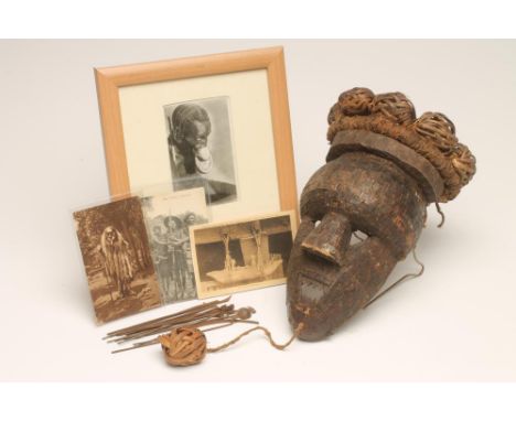 A SALAMPASU MASK, the face decorated with copper strips, cane spheres to the top and one hanging below the chin, 21 1/2" incl
