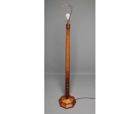 AN ADZED OAK STANDARD LAMP by Robert Thompson, of faceted tapering form with moulded collar and carved triangular top, steppe