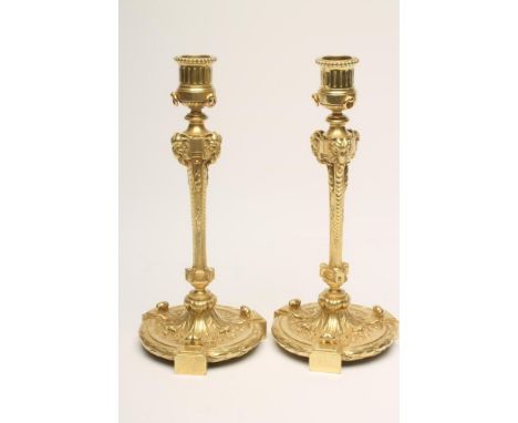 A PAIR OF FRENCH ORMOLU CANDLESTICKS stamped Maison Marnyhac, Rue de la Paix, the turned fluted and beaded edged sconce on ta