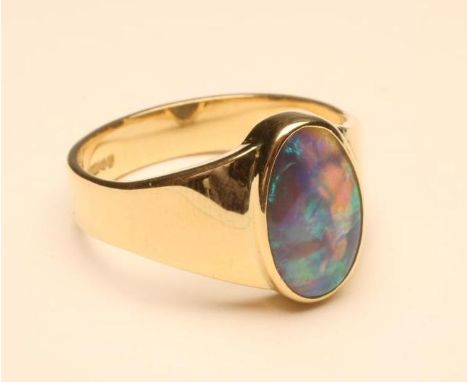 A GENTLEMAN'S 18CT GOLD RING, open back collet set with an oval cabochon polished black opal, size X (Est. plus 18% premium i