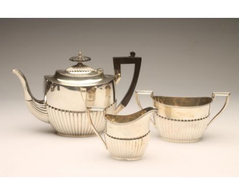 A THREE PIECE TEA SERVICE, maker Walker & Hall, Sheffield 1921, of semi-fluted oval form, comprising teapot with hinged cover