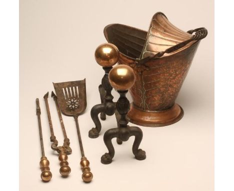 A PAIR OF ANDIRONS, c.1900, with large copper ball finial on wrythen turned iron upright, raised on crouching lion paw suppor