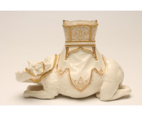 JAMES HADLEY FOR ROYAL WORCESTER-A CHINA CAMEL, c.1890, modelled recumbent with a gilt highlighted howdah, incised signature,