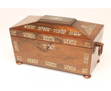 A REGENCY ROSEWOOD TEA CADDY of sarcophagus form with ring handles and raised upon four bun feet, all over inlaid in mother o