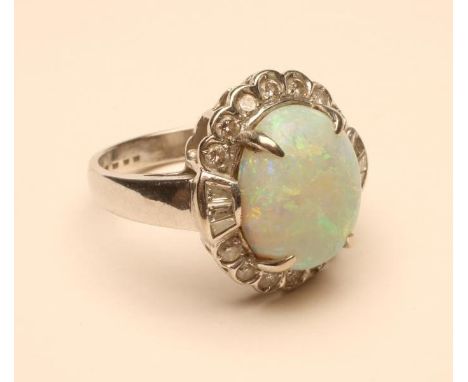 AN OPAL AND DIAMOND CLUSTER RING, the oval cabochon polished opal claw set to a border of fourteen old brilliant cut diamonds