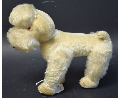 A Steiff Snobby Poodle, white blond fur, glass eyes, adjustable limbs, red tongue, brown moulded nose, missing ear button, 20