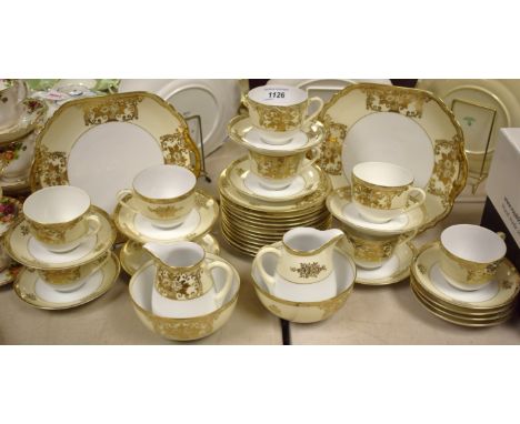 A gilt tea service made in Japan comprising a pair of bread plates, cream jugs, sugar bowls, tea plates, cups and saucers.