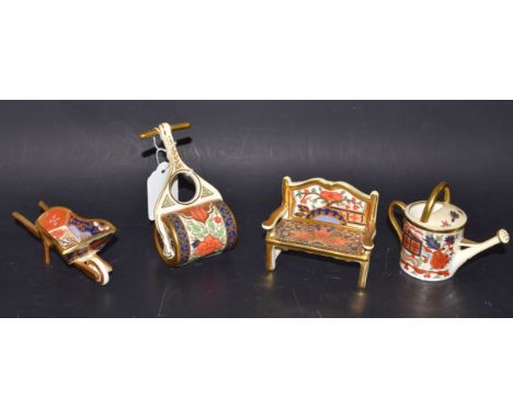 A Royal Crown Derby miniature garden bench; others similar; a wheel barrel, a garden roller, awatering can, first quality (4)
