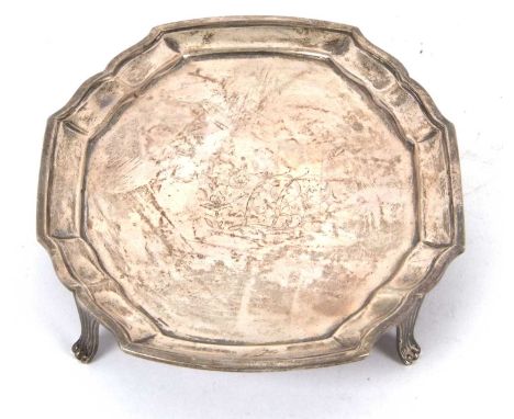 A George III silver teapot stand of shaped oval form having a slight raised border supported on four fluted feet in Neo-Class