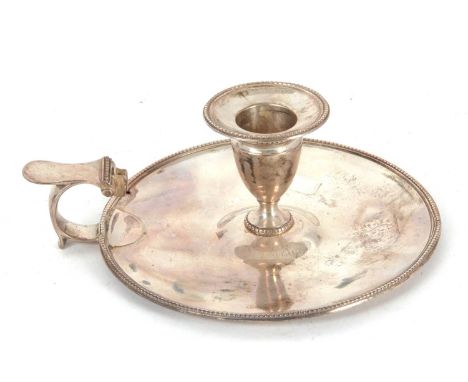 A George III silver chamber stick, the circular base plate and nozel with beaded rim detail, the flat top curved handle missi