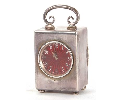 An Edwardian silver boudoir carriage clock having plain polished case, folding scroll carrying handle and raised on squat bun