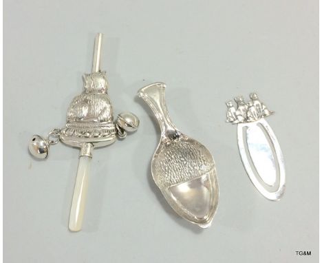 A silver babies rattle, a silver caddy spoon with acorn detail and a bookmark