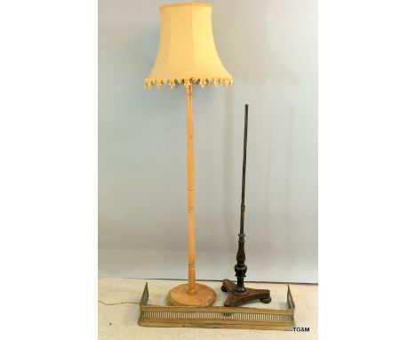 A brass fire surround and lamp standard with a mahogany base of a pole screen